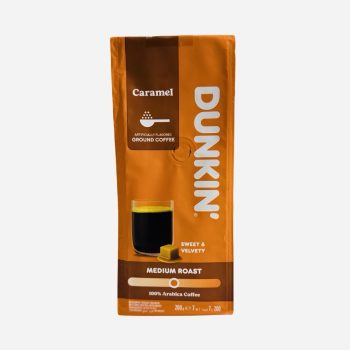 Dunkin caramel ground coffee bag in orange packaging, medium roast, 100% Arabica, with a glass of black coffee and a caramel square.