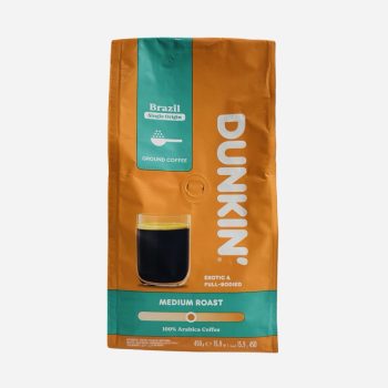 Dunkin medium roast ground coffee bag with orange/teal packaging and a glass of black coffee beside it